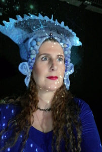 portrait of Raphaela Gilla at a live performance with her blue crown